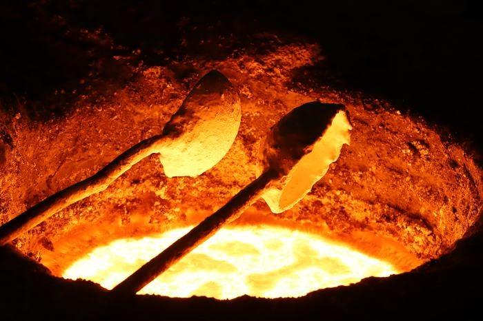 Cucharas con acero fundido sobre el horno